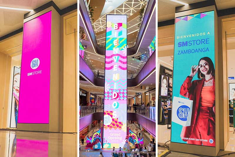 From pillar-mounted vertical LEDs to the multi-level atrium banner, SM Store moments extend brand storytelling, bilingual welcomes, and campaign artwork across the shopping floors.